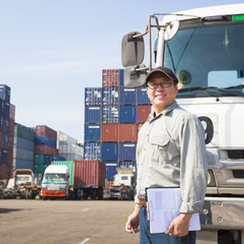 man in front of a lot of cargo smiling