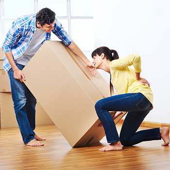 lady having back pain trying to lift a large box